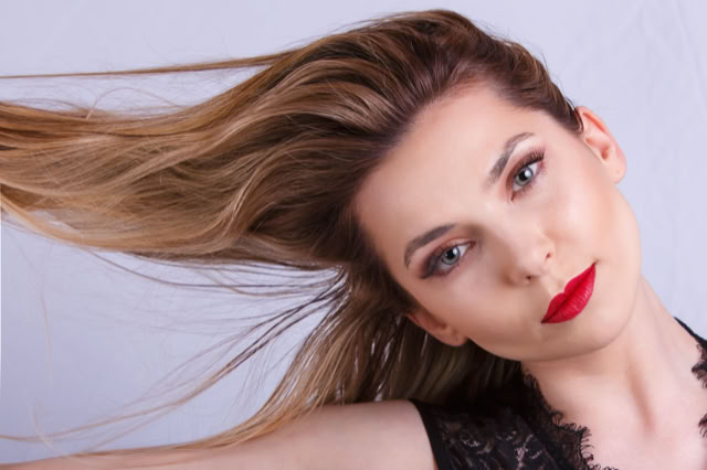 Przechylona głowa modelki. Blondynka z czerownymi ustami. Kobieca sesja zdjęciowa. Portret Kobiety.